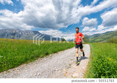 Ultra trail runner athlete prepares on a dirt road Ultra trail runner athlete prepares on a dirt road 50551783