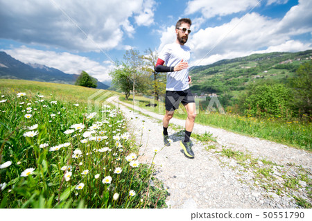 Daisies flowers when a blurred runner passes by on Daisies flowers when a blurred runner passes by on 50551790