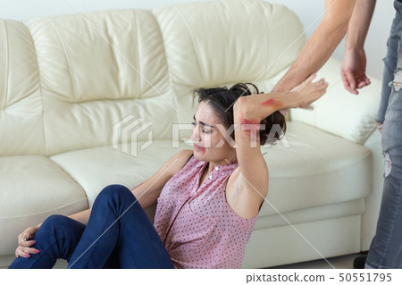 domestic violence, victim and abuse concept - cruel aggressive man grabbing woman lying on the floor 50551795