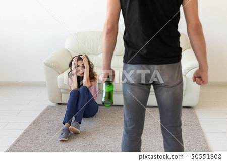 domestic violence, alcoholic and abuse concept - drunk man with bottle abusing his wife lying on the 50551808