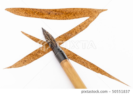 paintbrush with brown tip over brown brush strokes 50551837