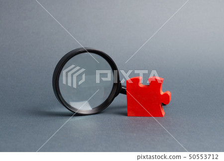 Red puzzle and magnifying glass.  50553712