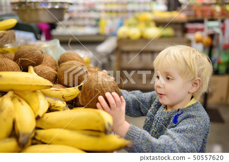 Cute little boy in a food store or a supermarket Cute little boy in a food store or a supermarket 50557620