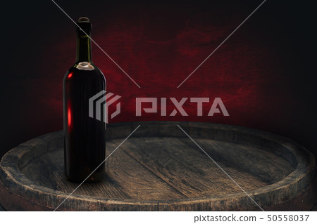 Red wine bottle on a old barrel table background Red wine bottle on a old barrel table background 50558037