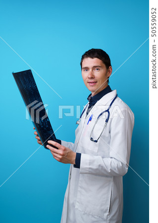 Portrait of a doctor with a stethoscope on the neck and an X-ray in hand 50559052