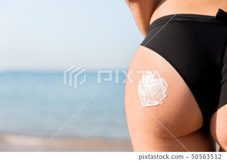 Tanned woman with sunscreen on body Tanned woman with sunscreen on body 50563512