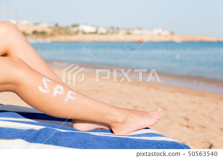 Tanned woman with sunscreen on body 50563540