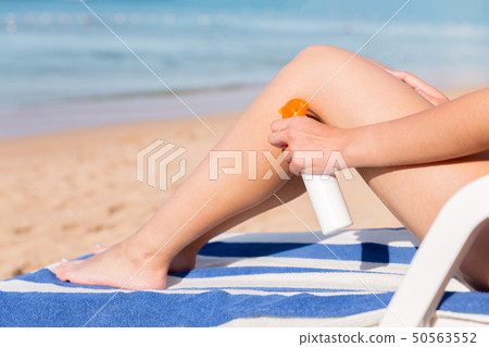 Tanned woman with sunscreen on body Tanned woman with sunscreen on body 50563552