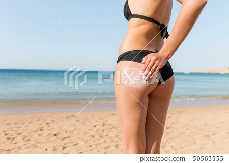Tanned woman with sunscreen on body 50563553