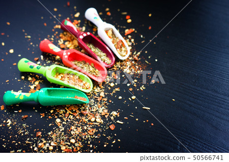 Spices and wooden spoons on black 50566741