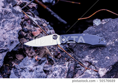 Military knife on the burnt stones. Knife. 50576689