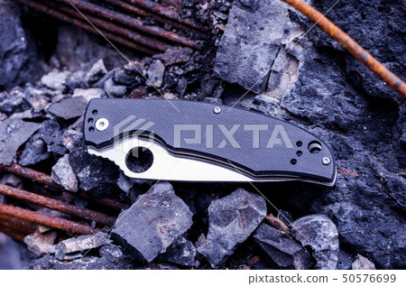 Knife blade with a hole. A knife on the rocks. 50576699