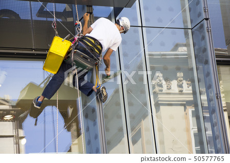 Window washer cleaning the windows of shopping 50577765