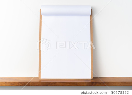 white flipped paper on clipboard on bookshelf 50578332
