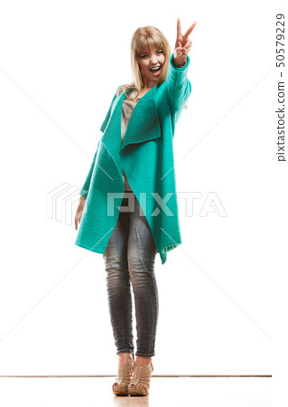 woman green coat showing victory sign 50579229