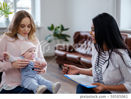 Mother with baby visiting pediatrician 50585061