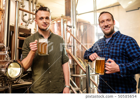 Two men tasting fresh beer in a brewery 50585654