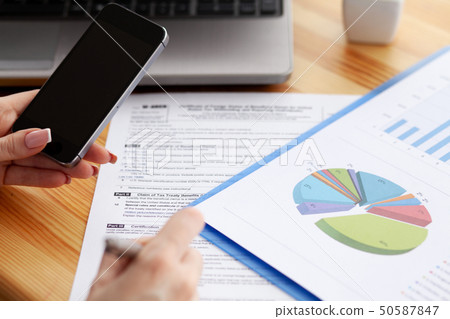 Contract. Blank of paper is on a wooden desk. Blank a4 paper is in the middle of wood office desk 50587847