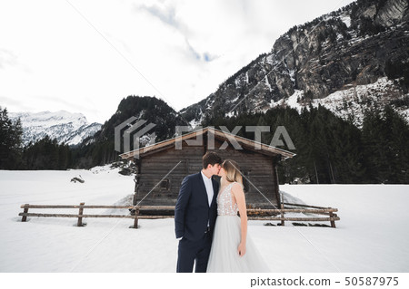 Young happy couple kissing, mountains landscape in snow on the background 50587975