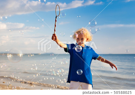 Kids blow bubble at beach. Child with bubbles Kids blow bubble at beach. Child with bubbles 50588025