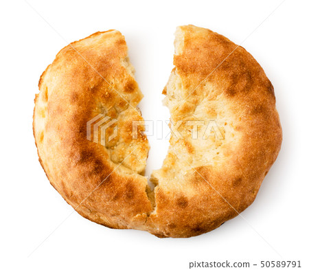 Fresh Uzbek flat cake broken in half on a white 50589791