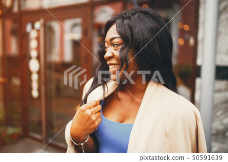 Black woman standing in a autumn city 50591639