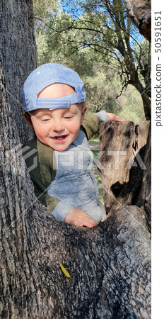 Smiling Little Baby Boy Climbing A Tree 50591651