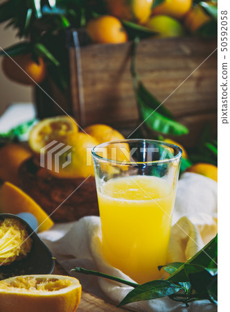 Table with box of fresh orange with orange tree branch and fresh orange juice Table with box of fresh orange with orange tree branch and fresh orange juice 50592058