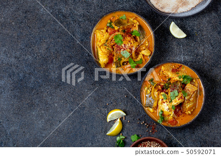 INDIAN FOOD. Traditional KERALA FISH CURRY with naan bread, gray plate, black background  50592071