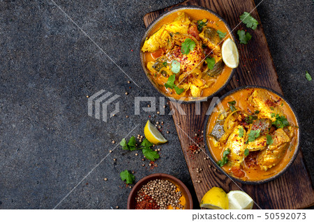 INDIAN FOOD. Traditional KERALA FISH CURRY with naan bread, gray plate, black background  50592073