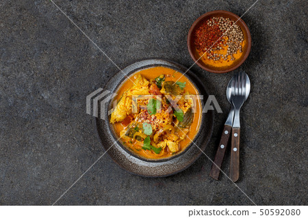 INDIAN FOOD. Traditional KERALA FISH CURRY with naan bread, gray plate, black background INDIAN FOOD. Traditional KERALA FISH CURRY with naan bread, gray plate, black background 50592080