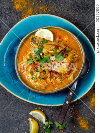 INDIAN FOOD. Traditional KERALA FISH CURRY with naan bread, gray plate, black background  50592099