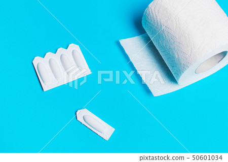 suppository and toilet paper on a blue background, 50601034