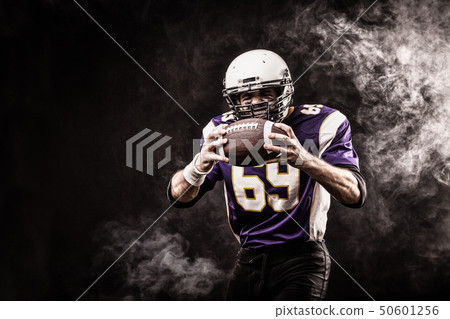 Football Player Holding Football With Both Hands Stock Photo