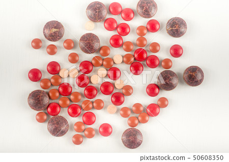 Many red brown pills on a white background. Many red brown pills on a white background. 50608350