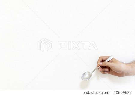 Man's hand holding a metal spoon Man's hand holding a metal spoon 50609625