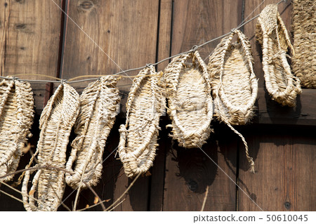 Straw sandals hanging in a line Straw sandals hanging in a line 50610045