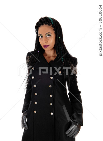 Young woman standing in black coat and cloves Young woman standing in black coat and cloves 50610654