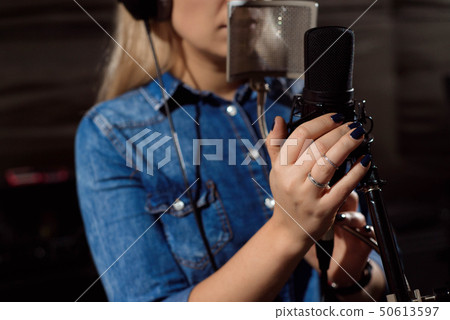 Close up of a singer recording a track in a studio 50613597