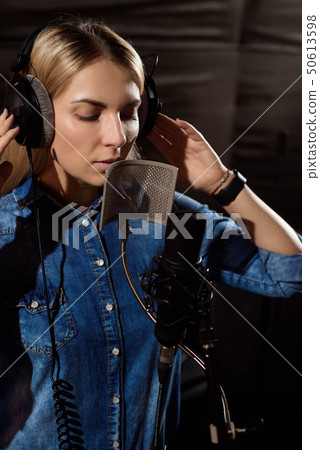 Close up of a singer recording a track in a studio 50613598