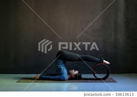 Girl in halasana pose doing yoga  50613613