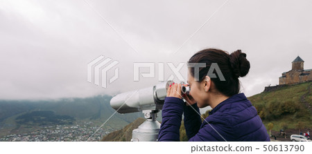 tourist woman looking at binoculars on a hillside tourist woman looking at binoculars on a hillside 50613790