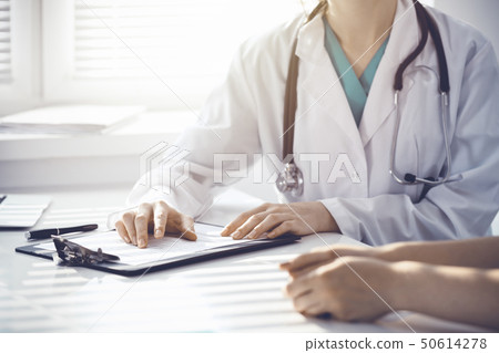 Doctor and patient are discussing something in clinic, just hands at the desk. Medicine and best 50614278