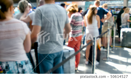 Out of focus image of people waiting in line for check-in on flight at airport terminal Out of focus image of people waiting in line for check-in on flight at airport terminal 50614527