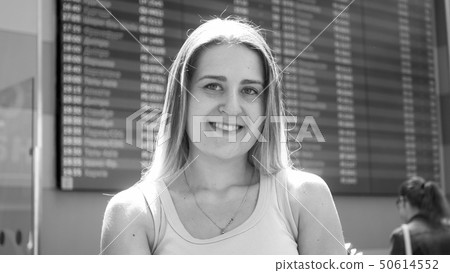 Black and white portrait of beautiful smiling woman posing in airport terminal before flight Black and white portrait of beautiful smiling woman posing in airport terminal before flight 50614552