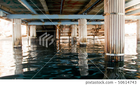 Image of sea waves and wooden colums under pier at sea shore 50614743