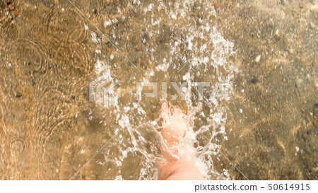 View from the top persons feet walking in sea waves 50614915