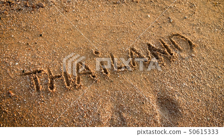 Closeup photo of word Thailand written on sea beach with golden sand. Concept of tourism, traveling 50615333