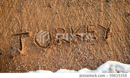 Closeup image of word Turkey written on wet sand at beach. Concept of tourism, traveling, trips and 50615350