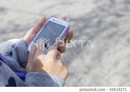 Child hand working with kids mobile outdoors Child hand working with kids mobile outdoors 50619271